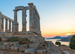 The legendary Temple of Poseidon standing tall against a golden sunset.