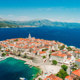Casco antiguo amurallado de Korcula en Croacia con un barco pequeno amarrado en el puerto